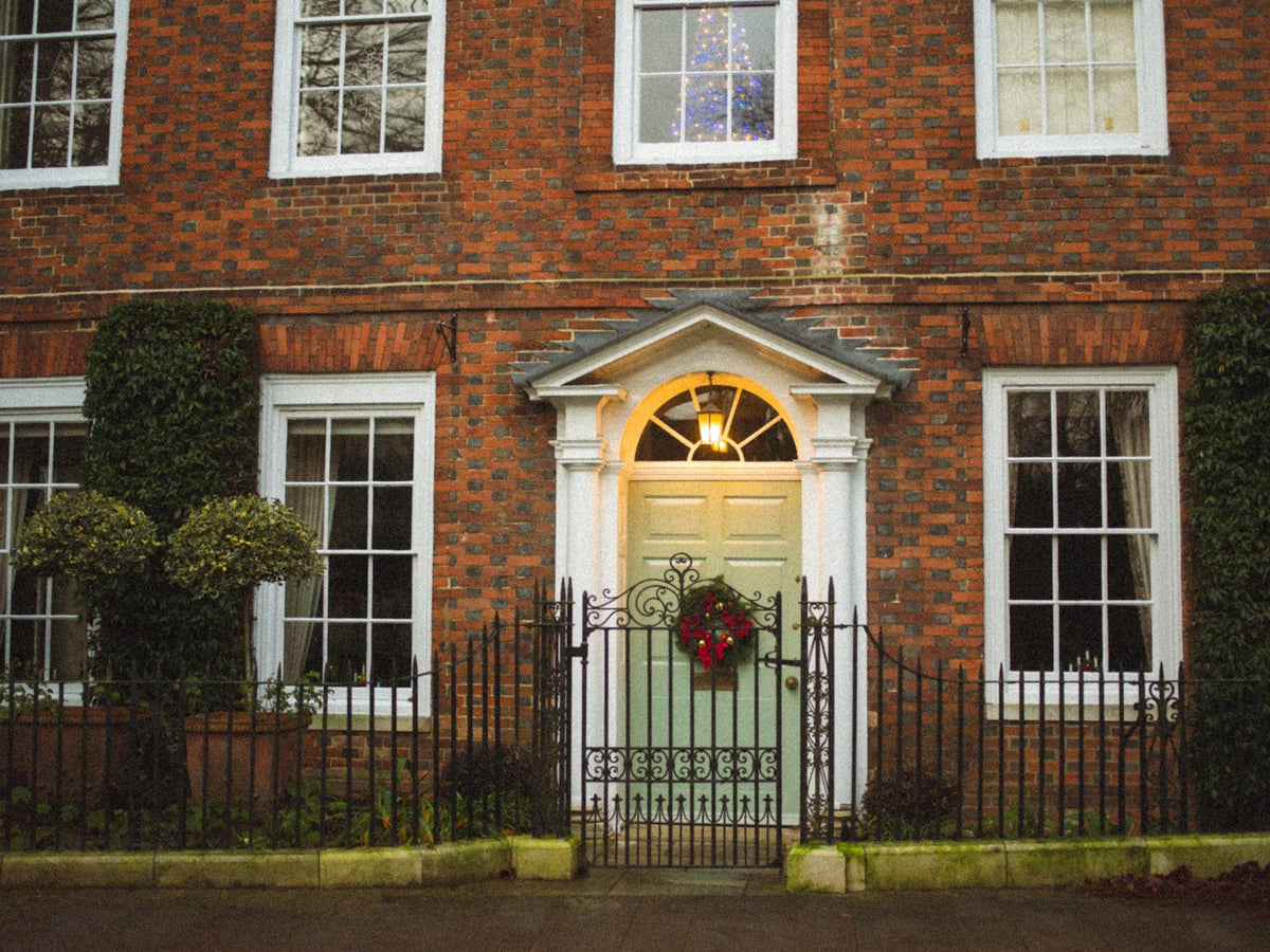 Green front door with a Christmas wreath