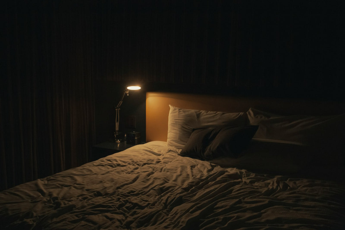 Table lamp glowing beside a bed