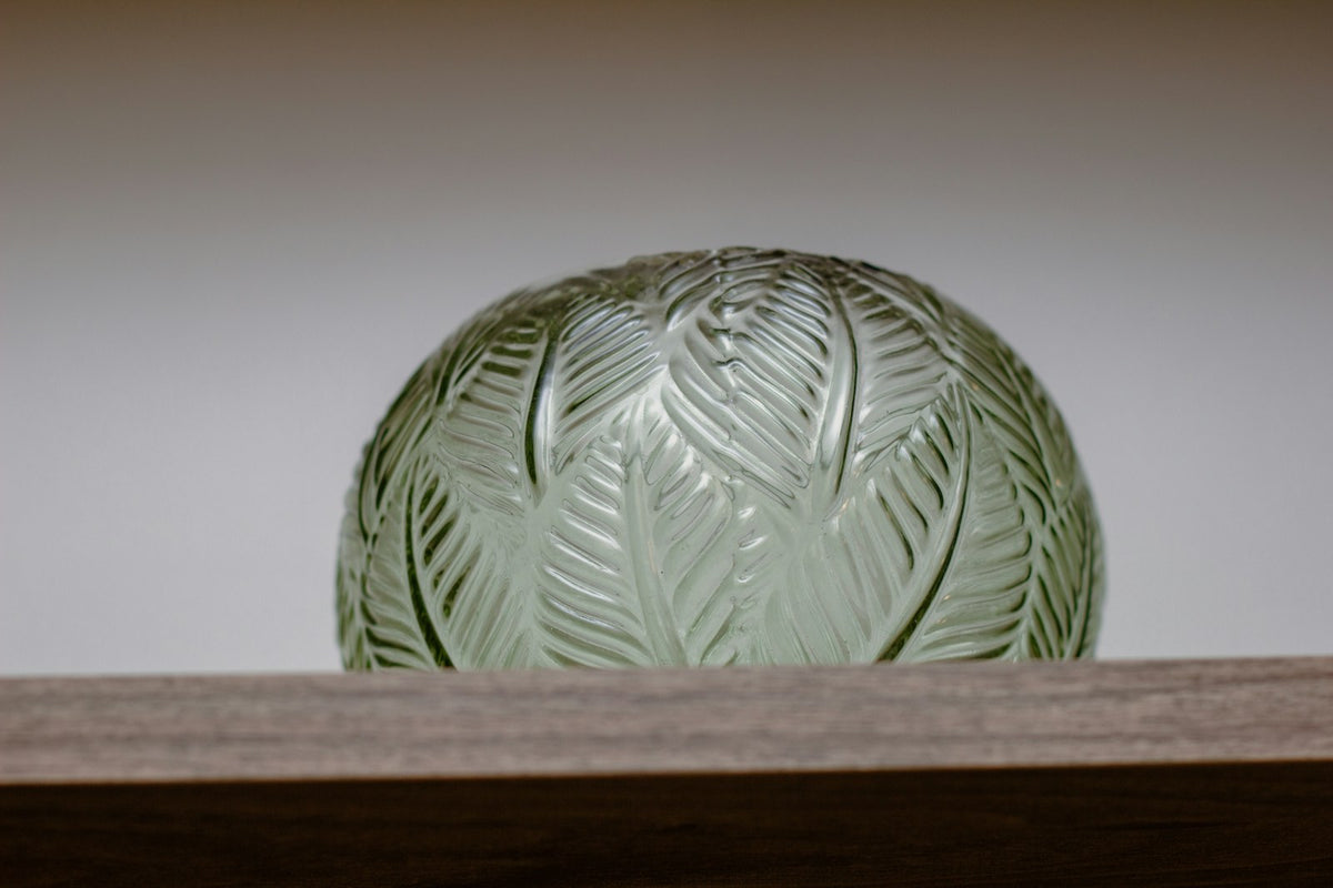 Green vase on a wooden shelf