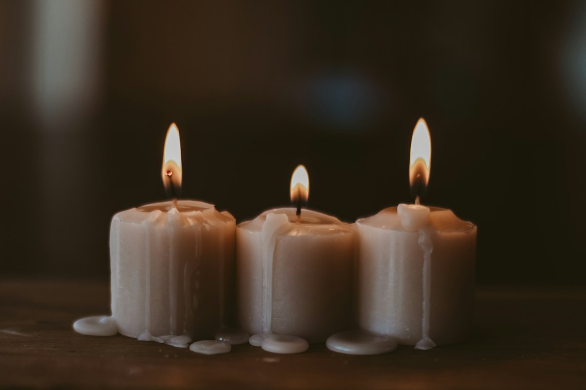 Candles glowing on a dark table